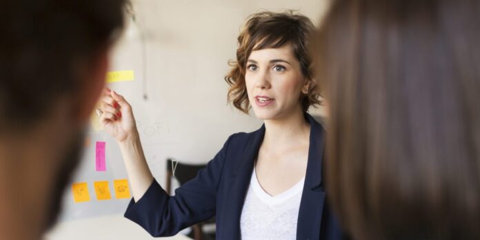Businesswoman explaining presentation to colleagues in office